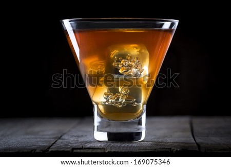 Single glass of whiskey (scotch, bourbon, rye) with ice cubes