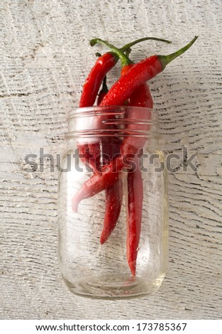 Closeup of organic red Jalapeno peppers spilling out of mason jar