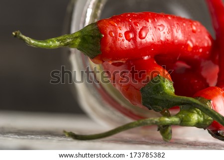 Closeup of organic red Jalapeno peppers spilling out of mason jar
