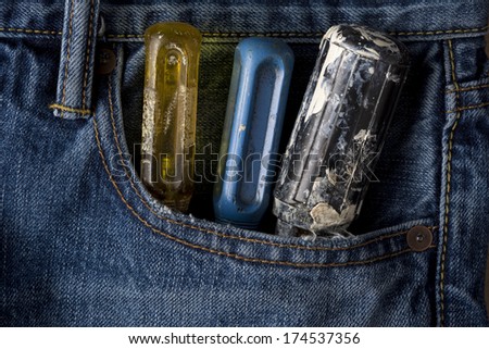 Closeup of screwdriver handles sticking out of blue jean pocket