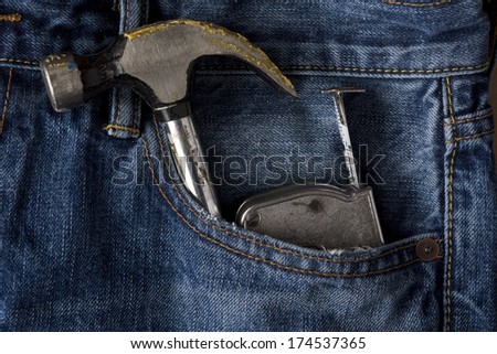 Hammer and tape measure sticking out of blue jean pocket