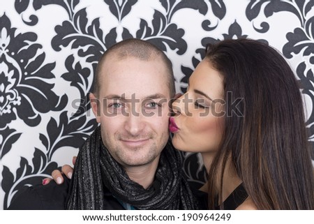 Playful attractive hipster couple with woman kissing man