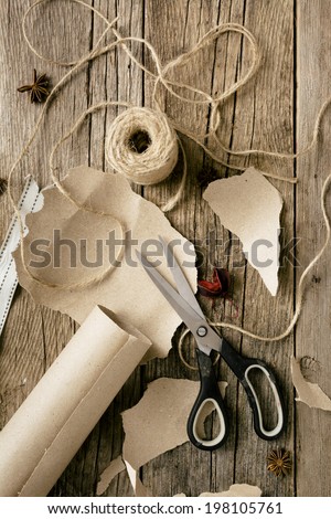 Overhead view of items ready to wrap gifts including brown paper and twine for Christmas or other holiday or occasion