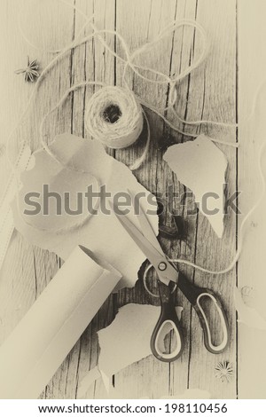 Overhead view of items ready to wrap gifts including brown paper and twine for Christmas or other holiday or occasion with vintage effect