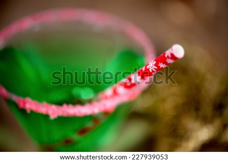Christmas emerald green cocktail, glass rimmed with crushed candy cane. Great drink for entertaining. Shot with focus on straw.