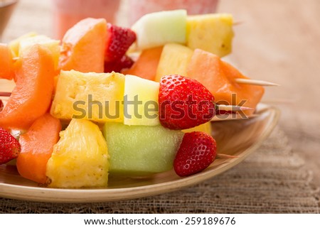 Fruit kabobs - fruit on skewers - on tray with strawberry smoothies