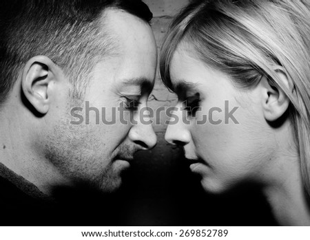 Portrait of man and woman in relationship in high contrast tight image in black and white