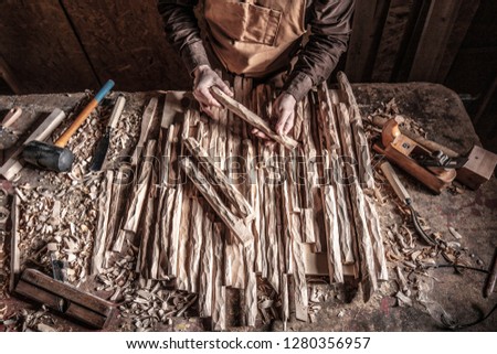 carpenter in workshop hold carved wood