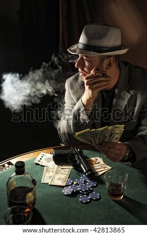 portrait of young gangster smoking and play poker