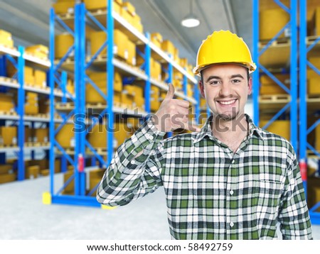 smiling worker in warehouse, call me pose
