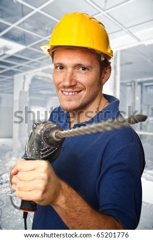 handyman holding electric drill and construction site background