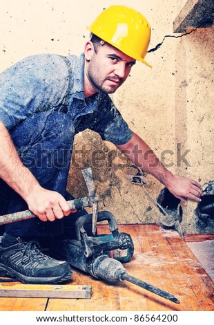 manual worker with hammer at construction site, indoor shot