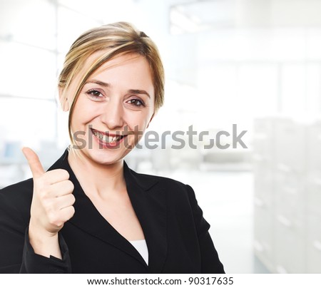 smiling young woman thumb up in modern office