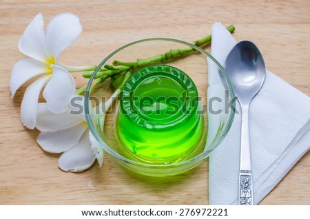 Green jelly in glass on the wooden floor.
