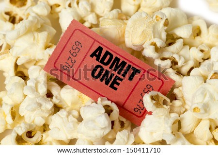 Movie Ticket In Center Of Popcorn/ Red Movie Ticket With Popcorn/ Close Up Of Popcorn With Ticket