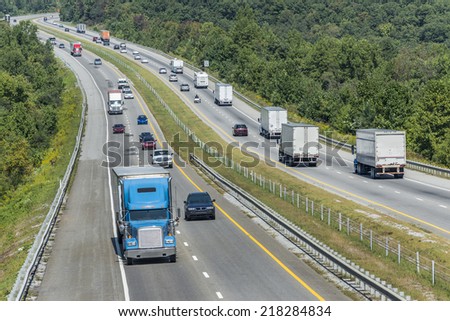 Mountain Highway With Oncoming Trucks In A Wooded Area/ Horizontal Shot