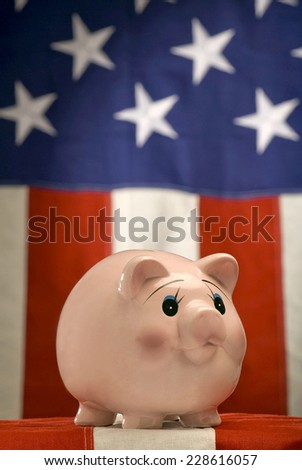 Vertical Shot Of Piggy Bank With American Flag in Background/Patriotic Piggy Bank/ Focus on piggy bank