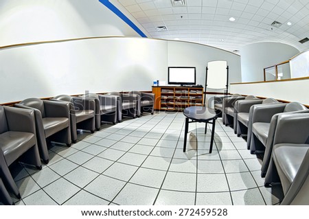 Fish Eye View Of Empty Chairs In Waiting Room With Blank Television Screen For Copy Space