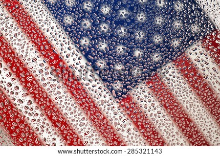 Diagonal Shot Of An American flag photographed through water drops on glass, creating many tiny mirror images of the flag/ Close Up American Flag Under Wet Glass