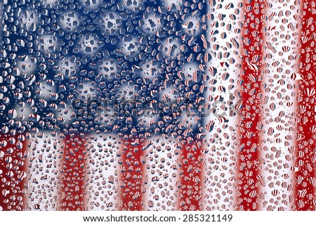 An American flag photographed through water drops on glass, creating many tiny mirror images of the flag/ American Flag Under Drops Of Water