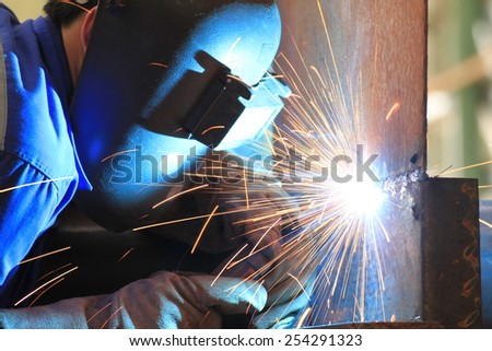 welder is welding steel plate with all safety