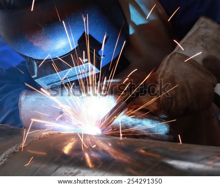 welder is welding big pipe with all safety
