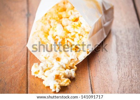 Popcorn paper bag opened with corn spilling out