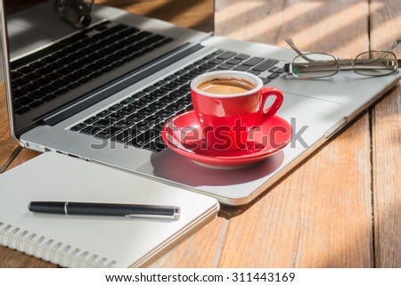 Hot coffee cup on wooden work station, stock photo