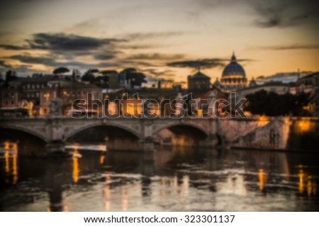 Artistic dark blur edit of a view of the Vatican City in Rome, Italy, at sunset, with river Tiber and a bridge