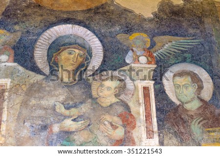 Rome, Italy - circa June 2015 - Ancient old roman fresco painting of the Blessed Virgin mary with child Jesus, angel and a saint. Detail of a fresco on the Roman Forum.