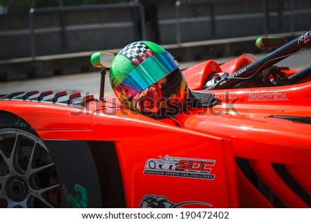 BRNO, CZECH REPUBLIC -?? APRIL 27, 2014: Crash helmet with racing gloves lie on the hood of race car during Histo Cup Austria racing event at Brno Circuit.