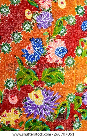 Batik design in Thailand for traditional clothes. Colorful orange tone background and flower style.