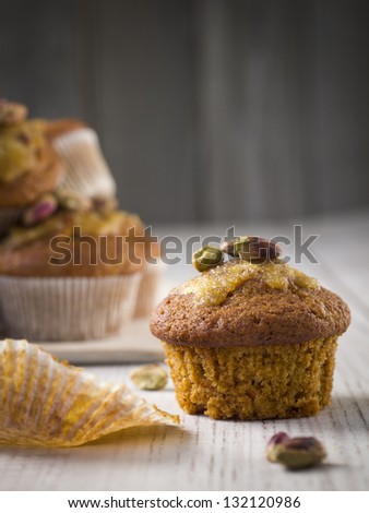 Whole grain carrot muffin with orange icing and pistachios.