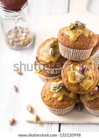 Whole grain carrot muffins with orange icing and pistachios.