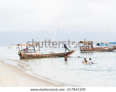 STONE TOWN - JULY 30, 2014: People on the beach in Stone Town, Zanzibar, on a weekend day. Zanzibar is a big tourist attraction of Tanzania.
