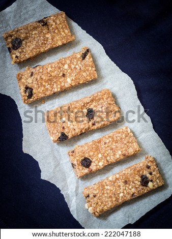 Homemade granola protein bars with peanut butter, honey, nuts, cacao and raisins.