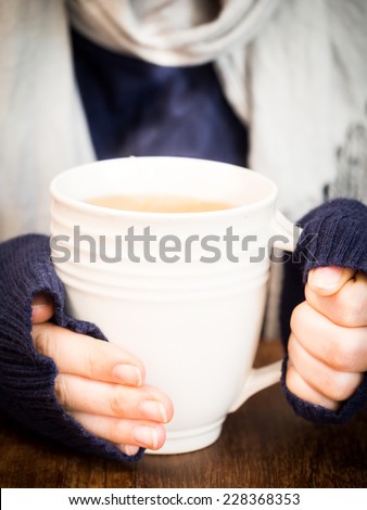 Young woman holding a cup of hot tea.