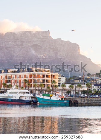 CAPE TOWN, SOUTH AFRICA - FEBRUARY 19, 2015: Waterfront in Cape Town, South Africa, overlooked by Table Mountain at sunset.