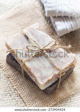 Vertical photo of two bars of homemade all natural hand crafted baobab and chocolate soaps on a burlap background. Overhead view, close up.