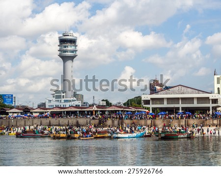 DAR ES SALAAM, TANZANIA - MAY 01, 2015: Horizontal photo of the waterfront of Dar es Salaam, Tanzania in East Africa, with maritime control tower and Mzizima fish market. Local people on boats i front
