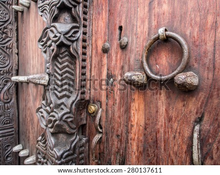 Horizontal photo of old traditional wooden carved door in Stone Town, Zanzibar, Tanzania, East Africa, close up.