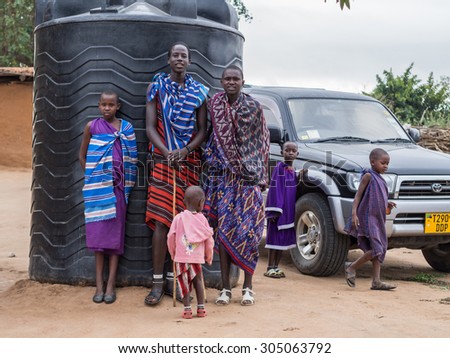 HANDENI, TANZANIA - AUGUST 01, 2015: Maasai children in front of a water tank in their boma (village) in Tanzania, Africa.