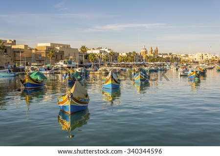 MARSAXLOKK, MALTA - NOVEMBER 11, 2015: Colorful painted wood boats with the typical protective eyes on a sunny day on November 11, 2015 in Marsaxlokk, Malta.