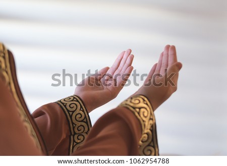 Islamic Dua Concept. Female hands.Peaceful spiritual moments. Hand raised up for praying to Allah.Hand of Muslim people praying with mosque interior background.