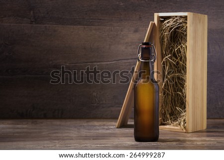 Craft beer bottle mock-up, beer bottle without label with a wooden gift box standing on a rustic table