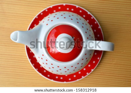 Red polka dot kettle on wooden table
