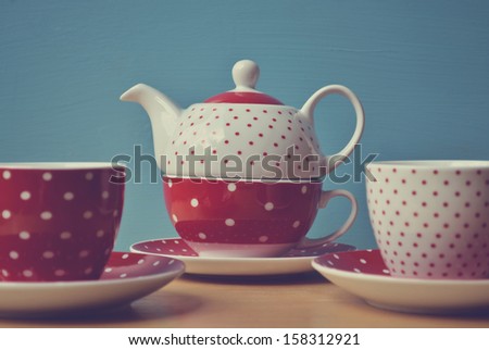 Red polka dots kettle with two cup of tea retro