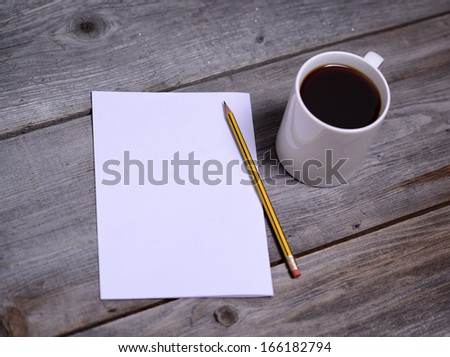 White mug of coffee and blank paper