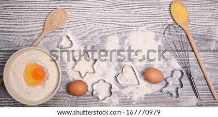 ingredients and molds for baking cookies on wooden