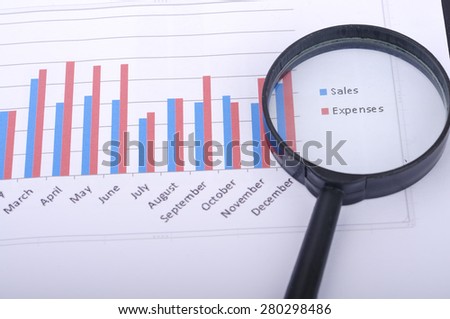 Magnifying Glass With Yearly Graph Bar Representing \
